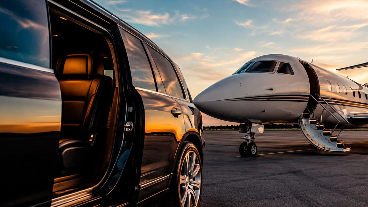 Carro de luxo na pista junto com um jato, ilustrando o artigo sobre como escolher a empresa de táxi aéreo ideal