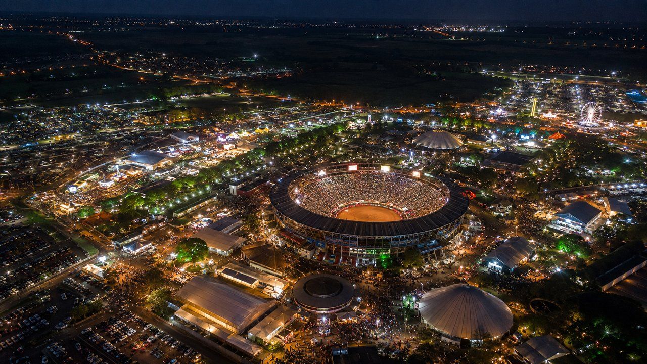 Vista aérea ilustrativa do Parque do Peão iluminado durante evento em Barretos